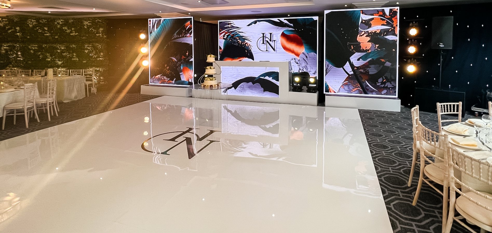 White seamless dancefloor with monogram, LED video wall backdrop and DJ booth